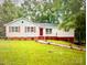Charming one-story home featuring a cozy front porch and red accents at 7154 Woodcock Trl, Stanley, NC 28164