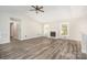 Spacious living room featuring luxury vinyl plank floors, a fireplace, and ample light at 7154 Woodcock Trl, Stanley, NC 28164