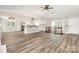 Bright, open-concept living space with luxury vinyl plank, kitchen view, and fireplace at 7154 Woodcock Trl, Stanley, NC 28164