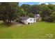 Aerial view of a white brick home showcasing its large, well-maintained lawn and mature trees at 80 Sumner Nw Ave, Concord, NC 28027