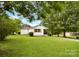Lush green backyard featuring a well-maintained lawn, mature trees, and a cozy home at 80 Sumner Nw Ave, Concord, NC 28027