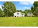 Expansive backyard features lush green grass, mature trees and a detached garage at 80 Sumner Nw Ave, Concord, NC 28027