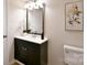 This bathroom features a modern vanity with black cabinets and gold hardware, plus an art piece at 80 Sumner Nw Ave, Concord, NC 28027