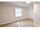 Neutral bedroom featuring light hardwood floors, updated window, and a closet with sliding doors at 80 Sumner Nw Ave, Concord, NC 28027