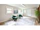 Bright living room featuring two stylish green chairs, neutral walls and a decorative area rug at 80 Sumner Nw Ave, Concord, NC 28027