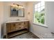 Bathroom boasts a wooden vanity with a white countertop, black hardware, and lots of light at 8337 Norcroft Dr, Charlotte, NC 28269
