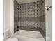 Stylish bathroom showcasing a modern tub with decorative tile surround and matte black fixtures at 8337 Norcroft Dr, Charlotte, NC 28269