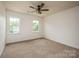 Bright bedroom with neutral carpeting, two windows, ceiling fan, and ample natural light at 8337 Norcroft Dr, Charlotte, NC 28269