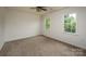 Bright bedroom with neutral carpet, ceiling fan, and ample natural light from two windows at 8337 Norcroft Dr, Charlotte, NC 28269
