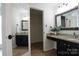 This bathroom is stylish, boasting double vanities with granite counters, a framed mirror, and ample storage in the closet at 8829 Gelligum Dr, Charlotte, NC 28277