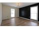 Spacious bedroom with two windows, hardwood floors, and a modern chandelier at 8829 Gelligum Dr, Charlotte, NC 28277