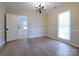 Inviting dining room features hardwood floors, a modern chandelier and large windows for plenty of natural light at 8829 Gelligum Dr, Charlotte, NC 28277