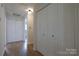 Hallway with hardwood floors and multiple closet doors for ample storage at 8829 Gelligum Dr, Charlotte, NC 28277
