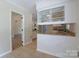 Open kitchen with tile floors, granite countertops, and white cabinets with glass fronts at 8829 Gelligum Dr, Charlotte, NC 28277