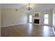Bright living room features wood floors, fireplace and chandelier, plus a door leading to the yard at 8829 Gelligum Dr, Charlotte, NC 28277