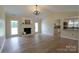 Bright living room with hardwood floors, a fireplace, a chandelier and an open view into kitchen at 8829 Gelligum Dr, Charlotte, NC 28277