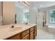 Bright bathroom featuring a double sink vanity, large mirror, and a separate shower with glass doors at 8909 Elkins Park Dr, Matthews, NC 28105