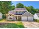 Charming gray two-story home featuring an attached two-car garage and mature landscaping at 8909 Elkins Park Dr, Matthews, NC 28105