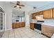 Functional kitchen offers tile floors, wooden cabinets, black and white appliances, and laminate countertops at 8909 Elkins Park Dr, Matthews, NC 28105