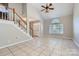 Bright living room with tile floors and staircase with wood handrail at 8909 Elkins Park Dr, Matthews, NC 28105