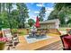 Spacious wooden back deck with dining set, umbrella, and rocking chair, ideal for outdoor entertaining at 1036 Foreman Ct, Denver, NC 28037