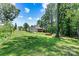 Lush backyard with a fire pit area, garden, and a detached garage, perfect for relaxation and outdoor activities at 1036 Foreman Ct, Denver, NC 28037