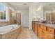 A full bathroom features a soaking tub, glass-enclosed shower, and a double vanity at 1036 Foreman Ct, Denver, NC 28037