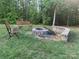 Outdoor fire pit area with stone seating, benches, and a serene setting, ideal for gatherings and relaxation at 1036 Foreman Ct, Denver, NC 28037