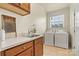 Bright laundry room features a sink, cabinets, and modern washer and dryer at 1036 Foreman Ct, Denver, NC 28037