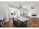 Modern kitchen island with a farmhouse sink, stainless steel dishwasher and a view of the living room fireplace at 108 Augusta Ln, Shelby, NC 28150