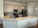 Modern kitchen featuring stainless steel appliances and a large kitchen island with countertop seating at 11608 Founders Park Ln, Pineville, NC 28134