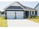 Charming home featuring a two-car garage, beautiful gray siding, and well-manicured lawn, creating great curb appeal at 12209 Riceland Way, Midland, NC 28107