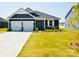 Charming home featuring a two-car garage, beautiful gray siding, and well-manicured lawn, creating great curb appeal at 12209 Riceland Way, Midland, NC 28107