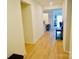 Inviting hallway with natural light, wood floors, and a seamless transition to the kitchen and living areas at 12209 Riceland Way, Midland, NC 28107