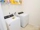 Practical laundry room equipped with a Whirlpool washer and dryer and shelving for storage at 12209 Riceland Way, Midland, NC 28107