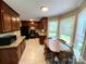 Charming eat-in kitchen featuring dark wood cabinets, granite countertops, and tile flooring at 12623 Levins Hall Rd, Huntersville, NC 28078