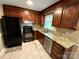 Kitchen with dark wood cabinets, granite countertops, stainless steel dishwasher, and black appliances at 12623 Levins Hall Rd, Huntersville, NC 28078