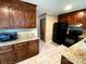 Kitchen showcasing granite countertops, dark wood cabinets, black appliances, and tile flooring at 12623 Levins Hall Rd, Huntersville, NC 28078