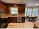 Bright kitchen with granite countertops, dark wood cabinets, and a view to the eat-in table at 12623 Levins Hall Rd, Huntersville, NC 28078