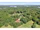 An aerial view of a home nestled among a dense forest, with a lake visible in the distance at 149 Vista Bluff Ln, Mooresville, NC 28117