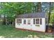 Backyard shed provides extra storage, featuring a shingled roof, double doors, and window boxes at 149 Vista Bluff Ln, Mooresville, NC 28117