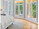 Bright bedroom with hardwood floors, large windows offering scenic backyard views, and soft, neutral decor at 149 Vista Bluff Ln, Mooresville, NC 28117