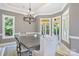 Elegant dining room featuring a modern chandelier, detailed trim, and abundant natural light from large windows at 149 Vista Bluff Ln, Mooresville, NC 28117