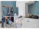 Well-lit laundry room features white cabinets, modern washer and dryer, and teal-painted walls at 149 Vista Bluff Ln, Mooresville, NC 28117