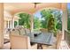 Covered patio with outdoor dining area, featuring a large table, comfortable seating, and views of the landscaped yard at 149 Vista Bluff Ln, Mooresville, NC 28117