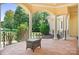 Covered veranda featuring classic columns, detailed railings, and views of the lush, landscaped surroundings at 149 Vista Bluff Ln, Mooresville, NC 28117