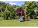 Spacious backyard featuring a wooden playset with a slide and swings, perfect for outdoor activities at 15211 Colonial Park Dr, Huntersville, NC 28078