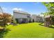 Wide view of a spacious backyard featuring a patio with pergola, playset, and lush lawn, great for outdoor fun at 15211 Colonial Park Dr, Huntersville, NC 28078