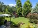 Lovely backyard featuring a shaded patio, playset, and garden beds, perfect for outdoor relaxation at 15211 Colonial Park Dr, Huntersville, NC 28078