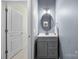 Powder room with gray vanity, oval mirror and wainscoting at 15211 Colonial Park Dr, Huntersville, NC 28078
